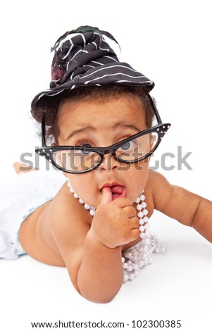 A cute six month old baby girl wearing old-fashioned style glasses and hat and a pearl necklace.