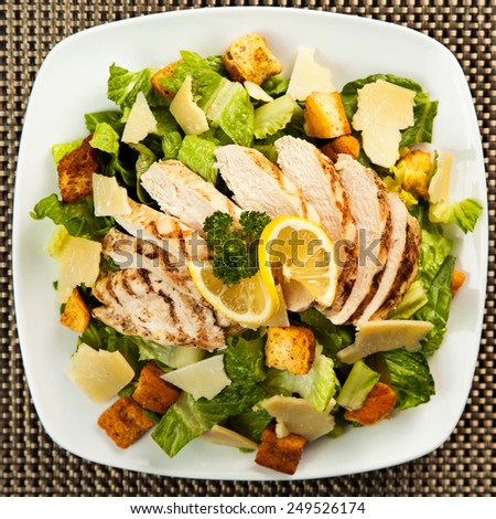 A healthy chicken caesar salad with Parmesan cheese and croutons