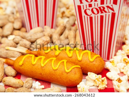 Classic American baseball park snack including two delicious corn dogs with piles of popcorn and peanuts