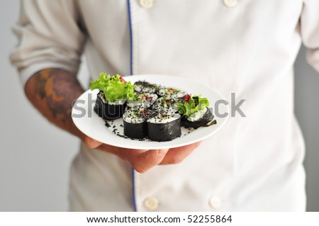 Sushi chef holding sushi plate