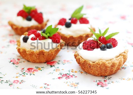 Berry tarts on a floral tablecloth