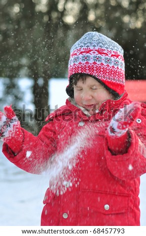 Toddler boy outside playing with snow