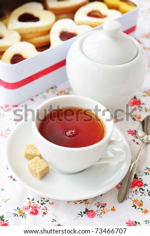 Cup of tea and heart-shaped cookies in a tin box