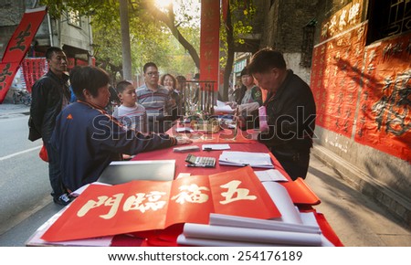 FOSHAN Feb 16:More than 30 calligraphers stall file write poetic couplet, attracted many people to buy, Chinese Spring Festival to paste the poetic couplet on the door Feb 16, 2015 in Foshan, China