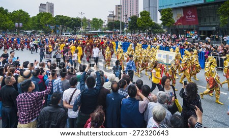 FOSHAN Apr 21:Birthday, Taoist god believers dressed in traditional clothing, carried the gods, patrol, residents along the way to watch and took out his camera phone  April 21, 2015 in Foshan, China