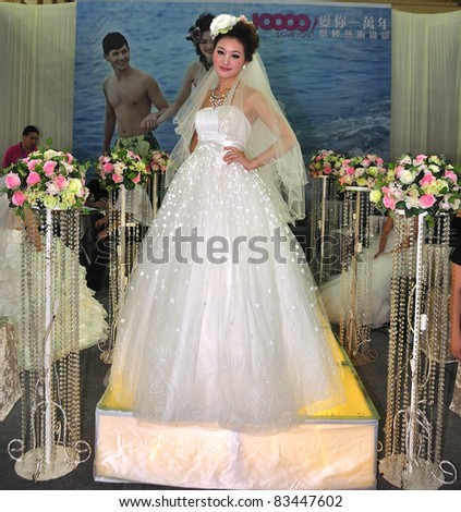 FOSHAN, CHINA–AUG 20: A model walks the runway at the Fall Wedding Expo 2011 at FoShan Stadium on August 20, 2011 in FoShan, China. More than 100 wedding photography, production planning companies took part.