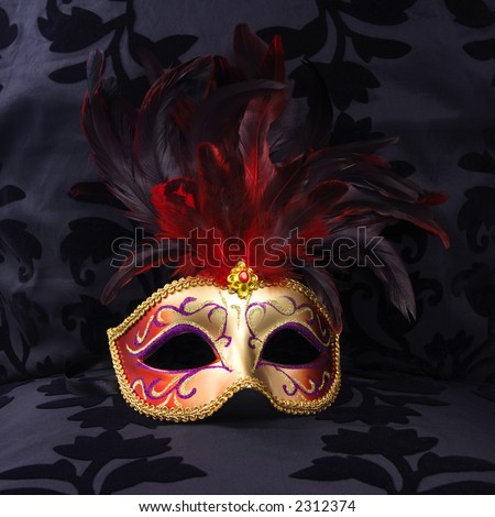 golden and red colored mask at a black velvet seat  (Venice, Italy)