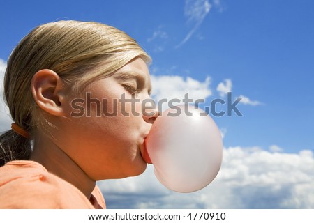 girl blowing a bubble with bubble gum (blue sky)