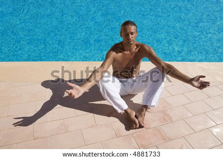 man meditating at the swimming pool side