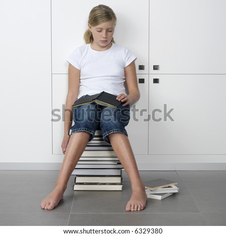 teenage girl who fell asleep over her books, while sitting on a stack of books