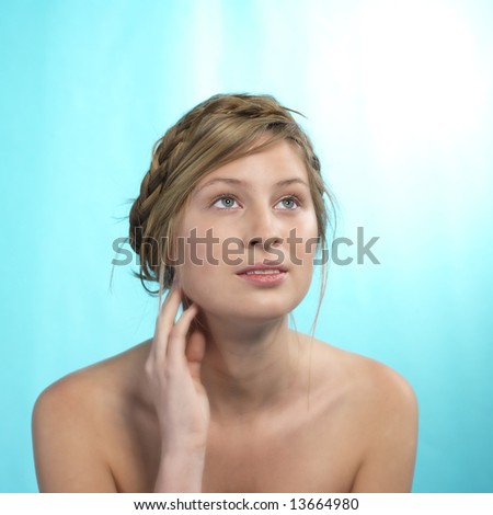 portrait of a beautiful blond girl looking up, pure setting, blue background