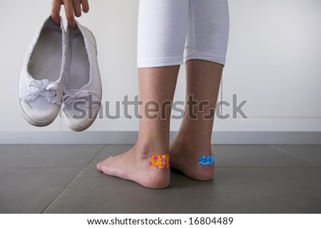 girl with colorful adhesive plasters on the blisters on her heels