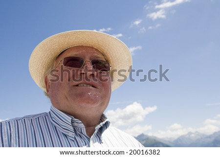 smiling older manwith sun hat, looking confident in the future