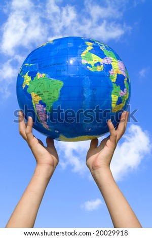 young girl holding the earth in her hands (blue sky)