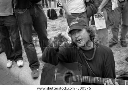 One of the many protesters sits in front of the White House playing guitar.