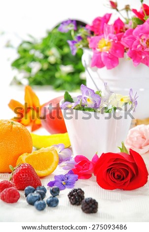 Breakfast brunch table fresh and sunshine morning, flowers, rose, viola, pink strawberry, orange, blueberry, blackberry, pear, pineapple, on yellow tablecloth and wood board, white bowl et rose petal.