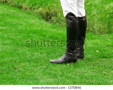 Jockey wearing black leather riding boots - stock photo