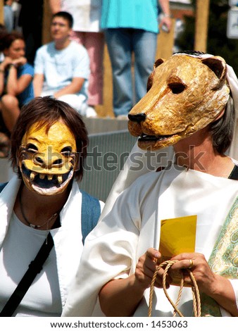 Two people wearing animal masks at street carnival