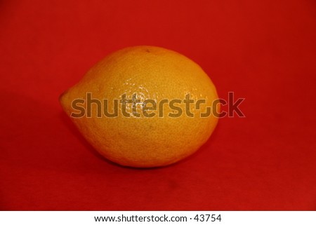 Single lemon on red background