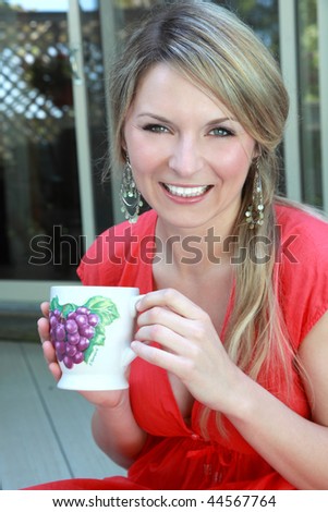 Woman drinking from funny grape mug
