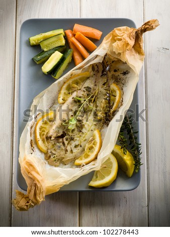 sole fish cocked in a wrapper with herbs and sliced lemon