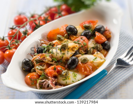 squid with tomatoes olives and capers, selective focus