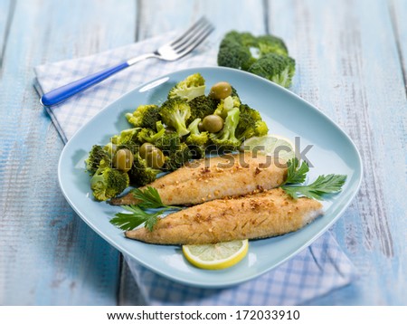 breaded fish with broccoli and olives, selective focus