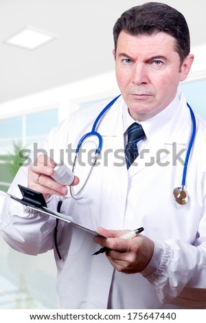 serious doctor with pills at hospital