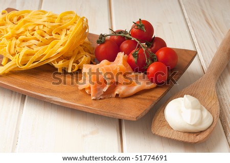 cutting board with ingredients for salmon pasta with cream sauce