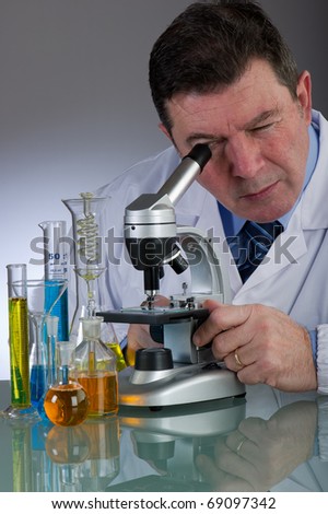 technician looking inside at microscope