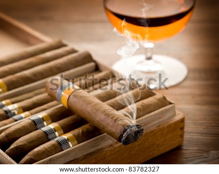 cuban cigar and glass of  liquor on wood background