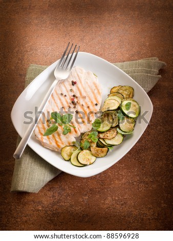 chest of grilled chicken with zucchinis and mint leaf