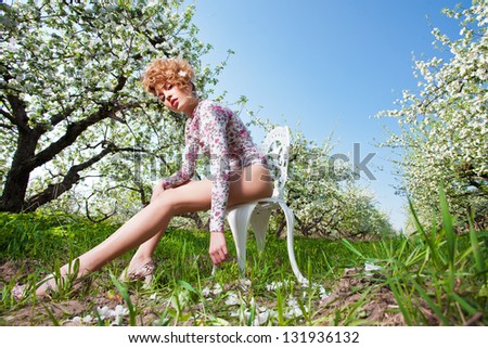 spring  fashion  blonde in the chair in a apple garden