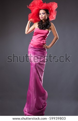Woman in pink evening dress with queue necklace and glamorous red hat