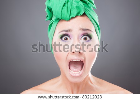 Scared woman with green scarf on head with wow expression; open mouth