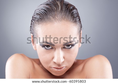 Desirable look from under the forehead of brunette woman with black-golden makeup