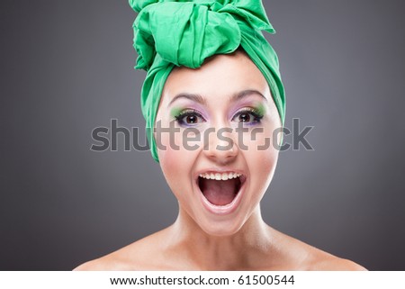 Happy smiling woman with green scarf on head and bright pink-green makeup