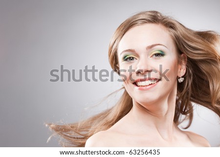 Happy smiling young woman with her hair blowing