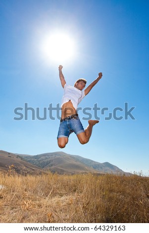 Happy young jumping man in the mountains