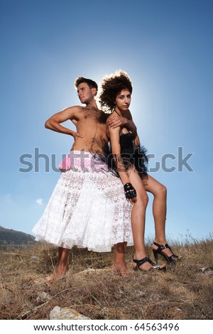 Fashion shot of unusual loving couple dressed in black and white; man embracing woman