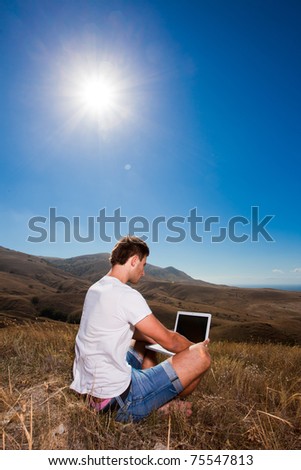 Man work on laptop in the mountains