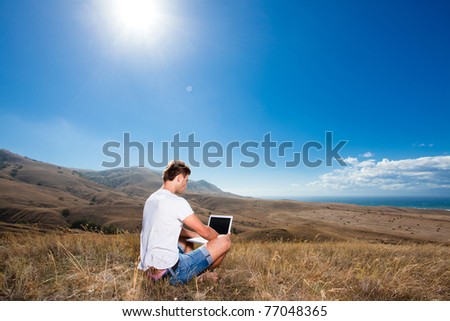 Man work on laptop in the mountains