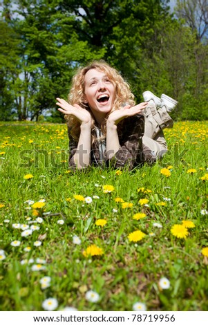 Happy surprised woman on flower field looking up