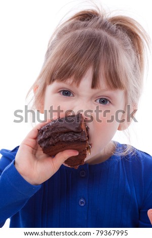 Hungry little girl eating chocolate cake looking at camera