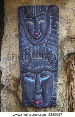 Traditional african mask hanging on grunge stone wall