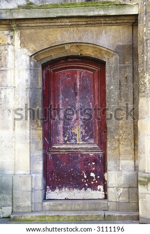 Grunge painted wooden door with bronze handles in Paris