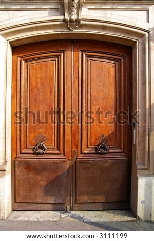 Grunge wooden door with bronze handles in Paris