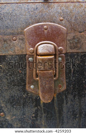 Grunge rusty latch on antique metal trunk - closeup