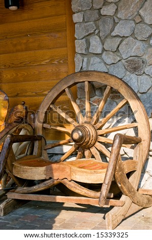 Rustic wooden bench with back made from old western stage coach wheel