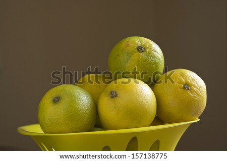 Healthful sweet lemons against dark brown backdrop